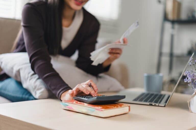 Woman reviewing retirement finances and calculating taxes at home