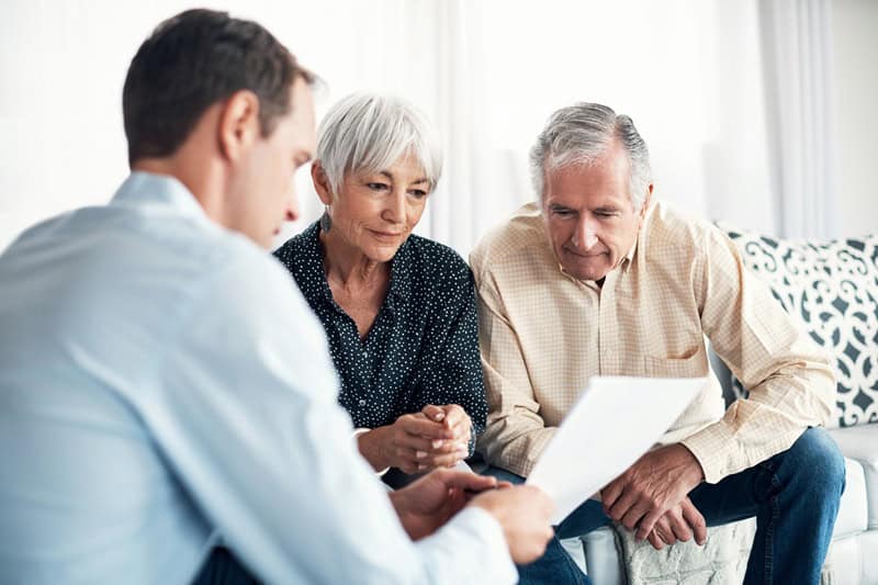 Financial advisor explaining Required Minimum Distributions (RMDs) and retirement tax planning to retirees.